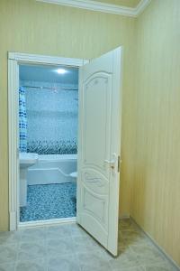 a bathroom with a tub and a toilet and a door at Gunesh Hotel Samarkand in Khodzha-Akhrar