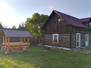 een houten huisje met een tuinhuisje in de tuin bij Wild-Traditional Bucovina in Câmpulung Moldovenesc