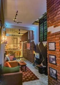 a living room with a couch and a brick wall at The Brick House Kandy in Kandy