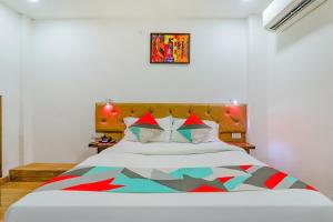 ein Schlafzimmer mit einem Bett mit einer bunten Decke darauf in der Unterkunft FabExpress The Mall Inn in Kānpur