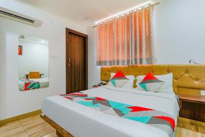 um quarto com uma cama grande e uma janela em FabExpress The Mall Inn em Kanpur