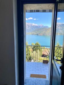 a door to a balcony with a view of a lake at Greenlake House Tremezzina in Tremezzo