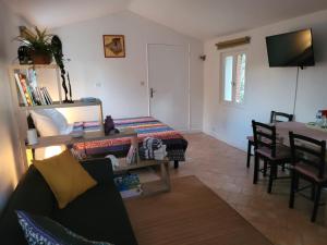 a living room with a bed and a table and chairs at Domaine de La Mayonnette in La Crau