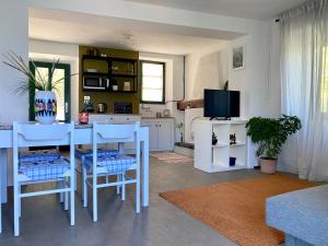 uma sala de estar com uma mesa e uma televisão em Greenlake House Tremezzina em Tremezzo