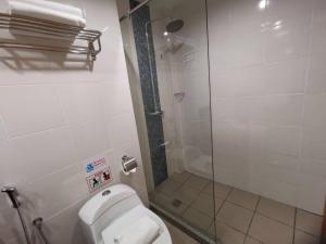 a bathroom with a toilet and a glass shower at TD CAPITAL HOTEL in Inanam