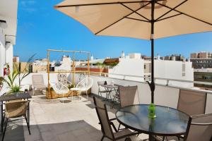 eine Terrasse mit Tisch und Stühlen und einem Sonnenschirm in der Unterkunft Estudio Massimo 7d in Las Palmas de Gran Canaria
