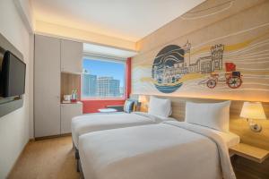 班加罗尔ibis Bengaluru Hebbal - An Accor Brand的两张位于酒店客房的床,墙上挂着一幅画