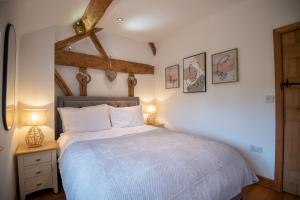 a bedroom with a bed and two lamps on a table at Bramble Cottage - Cosy 2 Bed With Deluxe HOT TUB & Log Burner in Hereford