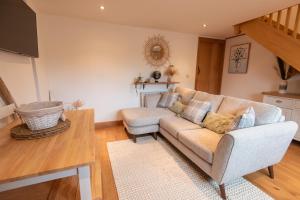 a living room with a couch and a table at Bramble Cottage - Cosy 2 Bed With Deluxe HOT TUB & Log Burner in Hereford