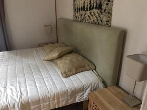 een kleine slaapkamer met een bed met witte lakens en kussens bij Kaaro 2 Cottage in Hillosensalmi