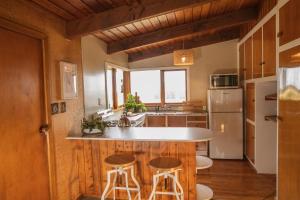 a kitchen with a white counter and stools in it at Washpen Falls in Windwhistle
