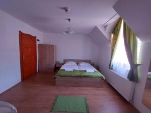 - une chambre avec un lit dans une pièce dotée d'une fenêtre dans l'établissement Csipke Vendégház, à Orfű
