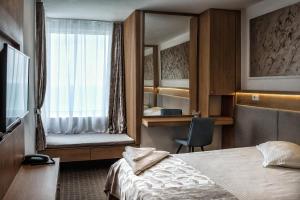 a hotel room with a bed and a mirror at Complex Hotelier Steaua de Mare - Hotel Delfinul in Eforie Nord