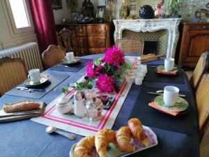蒙布里松的住宿－CLOCHI-CLOCHA，一张蓝色桌子,上面摆放着糕点和羊角面包