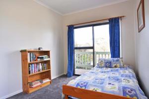a bedroom with a bed and a book shelf and a window at Aqua Escape On Anderson - Free Wifi & Netflix - Pet Friendly Outside Only in Inverloch