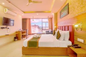 a hotel room with a bed and a window at The Glory Hotel in Dehradun