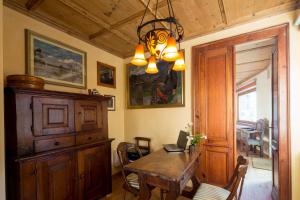 comedor con mesa y lámpara de araña en Walser House, en Rimella