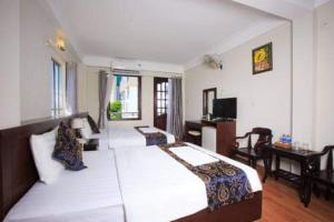 a bedroom with a large white bed and a desk at PHỐ BIỂN HOTEL in Nha Trang