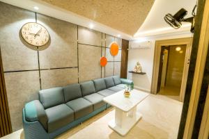 a living room with a couch and a clock on the wall at Jeyam Residency in Puducherry