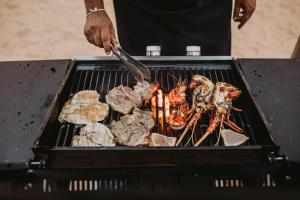 a person is cooking food on a grill at Karpaha Sands in Pasikuda