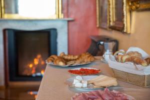 a table with several plates of bread and a fireplace at Walser House in Rimella +9 photos