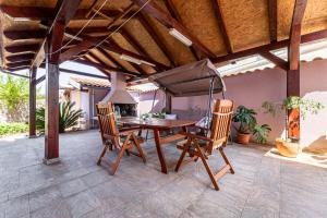 a table and chairs on a patio with an umbrella at Malinsummer Apartments in Malinska