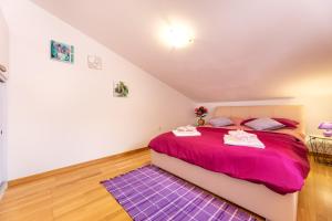 a bedroom with a purple bed and a purple rug at Malinsummer Apartments in Malinska