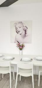 a white table with white chairs and a picture of a woman at Marilyn príjemný 3 izbový byt v Rači in Rača