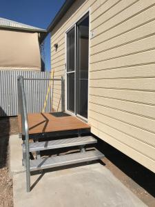 a wooden bench sitting on the side of a building at Australian Hotel Winton Budget Hotel Accommodation in Winton