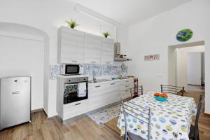 een keuken met een tafel, een fornuis en een koelkast bij La Colombera in Alassio