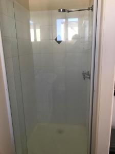 a shower with a glass door in a bathroom at Australian Hotel Winton Budget Hotel Accommodation in Winton