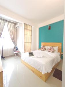 胡魯馬利的住宿－維盧休閒旅館，一间卧室设有一张床和蓝色的墙壁