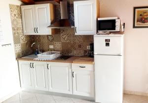 a kitchen with white cabinets and a white refrigerator at Apartments Karmen Funtana in Funtana