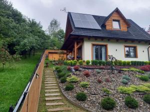 a house with solar panels on the roof at Gorczańskie Domki in Łopuszna