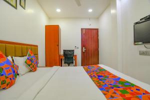 sypialnia z łóżkiem i telewizorem na ścianie w obiekcie FabHotel Day2Day w mieście Indore