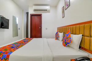 インドールにあるFabHotel Day2Dayのベッドルーム(大きな白いベッド、カラフルな枕付)