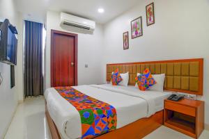a bedroom with a large bed with colorful pillows at FabHotel Day2Day in Indore