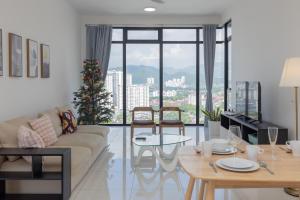 - un salon avec un canapé et une table avec un arbre de Noël dans l'établissement Beacon Executive Suite Penang, à George Town