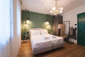 1 dormitorio con cama blanca y pared verde en AL TIGLIO, en Farra di Soligo