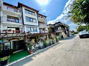 a building with tables and chairs on a street at Saint George - Old Nesebar in Nesebar