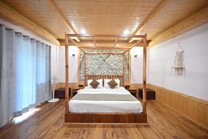 a bedroom with a bed and a brick wall at The Hillside in Kasol