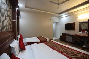 ein Hotelzimmer mit zwei Betten und einem Fernseher in der Unterkunft HOTEL JAGDISH RESIDENCY in Katra
