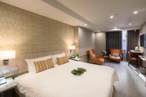 台北市にあるComma Boutique Hotelの大きなベッドとデスクが備わるホテルルームです。