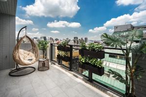 uma varanda com uma cadeira e plantas num edifício em Comma Boutique Hotel em Taipei