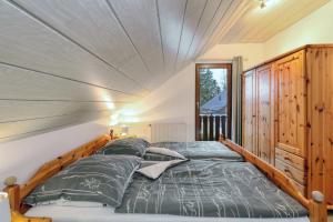 a bedroom with a bed with a wooden headboard at Ferienhaus Diane in Kirchheim