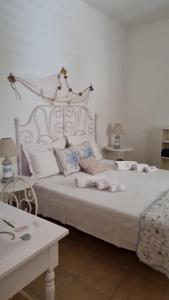 a bedroom with a large white bed with pillows at Soluzionestate in Ispica