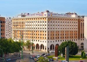 a large building with cars parked in front of it at Portico Sevilla in Seville