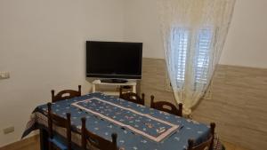 a dining room with a table and a tv and a table and chairs at Soluzionestate in Ispica