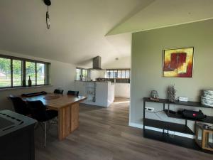 a kitchen and living room with a table and chairs at Vakantiehuisje Hoofdvaart in Dedemsvaart