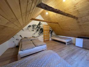 a attic room with two beds and a mountain mural at Wioska Kowala in Tyrawa Wołoska